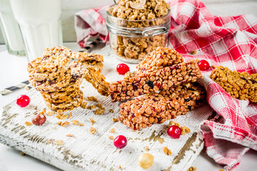 Multi grain granola muesli bar. Healthy sweet food, diet snack, with dried berries, nuts, cereals and honey. On a white marble background, top view copy place for text.