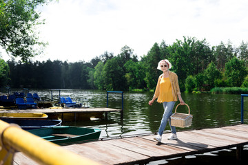 Crossing bridge. Stylish aged woman crossing the bridge while heading to the beach for having romantic dinner
