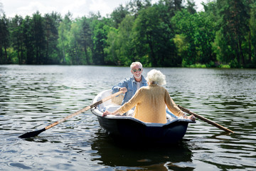 Fototapeta na wymiar River trip. Couple of happy pensioners wearing fashionable clothes enjoying their amazing river trip