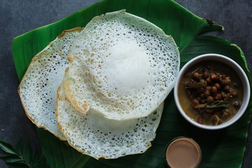 Palappam/ Paalappam - Kerala Appam with Kadala Curry tea on banana leaf, top view