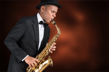 Close-up man playing on saxophone on white background