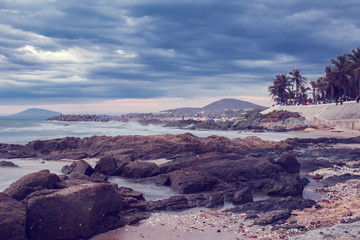 View of a rocky coast at the sunset. Dramatic sea view before rain