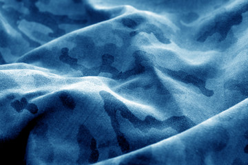 Old camouflage cloth with blur effect in blue.
