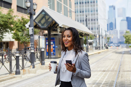 Businesswoman using cellphone in light rail station