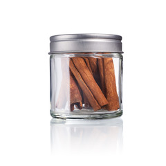 cinnamon sticks in a glas with metal lid, isolated on white