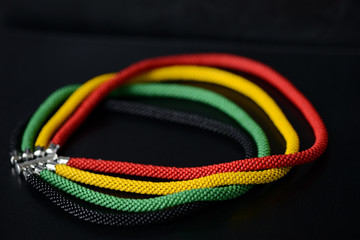 Beaded necklace in Jamaican style on a dark background close up