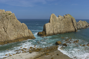Fototapeta na wymiar Rocks on the beach. Dramatic view of Playa de la Arnia, rocky coastline in Santander ,Cantabria, Spain.