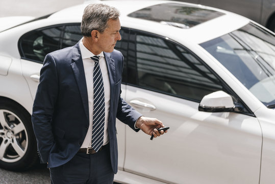 Businessman using remote control key of car