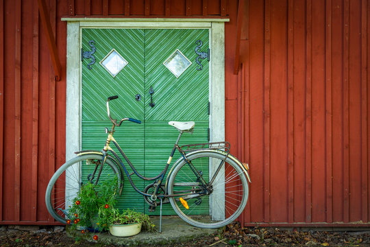 Cykel parkerad framför ytterdörr på liten stuga