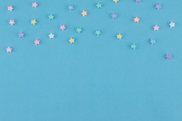 Pastel stars on blue background with copy space