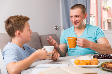Man with his son are talking about life together in time lunch