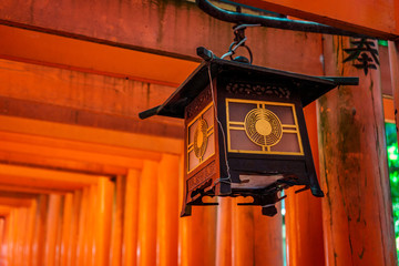 Traditional Japanese wooden lantern on a red Torii pillar in Fushimi Inari-taisha Shrine, Kyoto, Japan