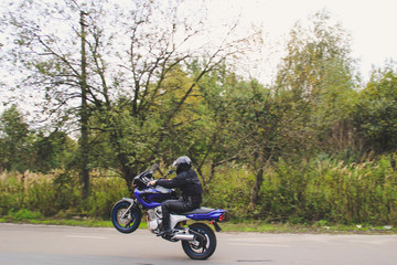 Fototapeta na wymiar Dark blue motorbike on wheelie. Motorcycle on the parking lot. Ukraine, Lviv.