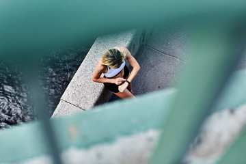 Anonymous sportswoman checking fitness tracker near border