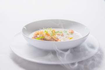 Cream mushroom soup with scallops, herbs, toast bread and dried ice mist.