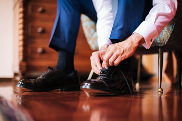 Datail of a groom putting on his shoes