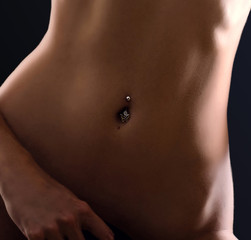 Crop photo of perfect female body. Navel piercing - obrazy, fototapety, plakaty