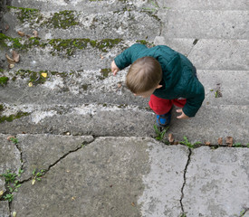 A little boy is climbing the stairs.