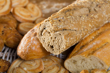 Fototapeta na wymiar Cut wholegrain baguette with bakery products