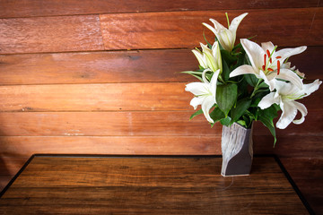 Fresh white flowers in a vase on a wooden floor...