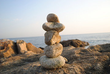 Fototapeta na wymiar ZEN - Conjunto de pedras empilhadas em ambiente de praia com horizonte ao fundo