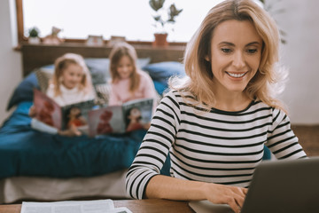 Professional freelancer. Smart cheerful woman using her laptop while working from home