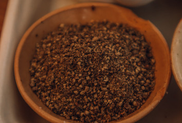 Ground black Peppercorns on old wooden table. Peppercorn Varieties. Milled black pepper. Black pepper corns and Black pepper Powder on wooden background. Close up, soft focus.