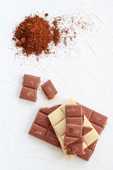 Coffee,white and milk chocolate. Tiles of chocolate on a white background.