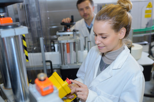 happy female scientist working on a machine in modern lab