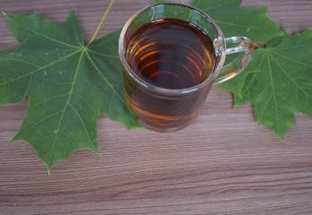 Cup with tea with maple leaves