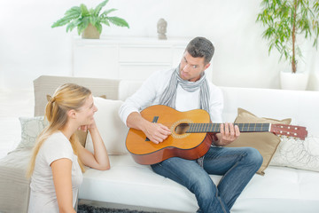 Man playing guitar to lady