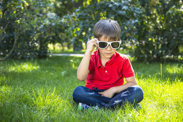 Adorable child boy in sunglasses playing outdoor.