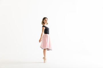 Female Ballet Dancer Maintaining Balance Over White Background