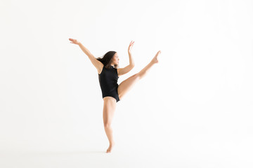 Fototapeta na wymiar Female Performer Practicing Ballet Moves Over White Background