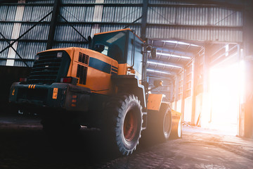 Obraz premium Heavy wheel loader excavator machine loading sand at quarry in a warehouse.