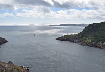 Obraz premium high angle view of a small nautical vessel entering the Narrows at the St John's harbour entrance on a cloudy Summer day, Avalon Peninsula, Newfoundland Canada