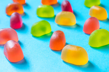 Multicolored gummy candies on a blue background