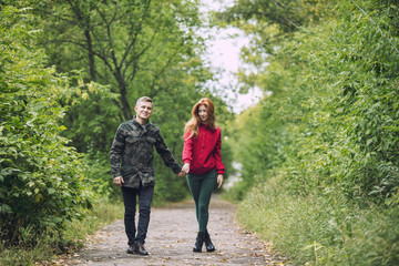 Young adult beautiful couple in love man and woman walking together in nature in the Park happy and beautiful