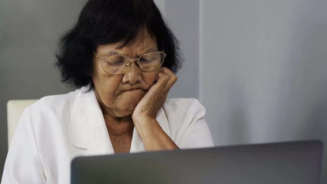 stressed senior woman working on laptop computer 