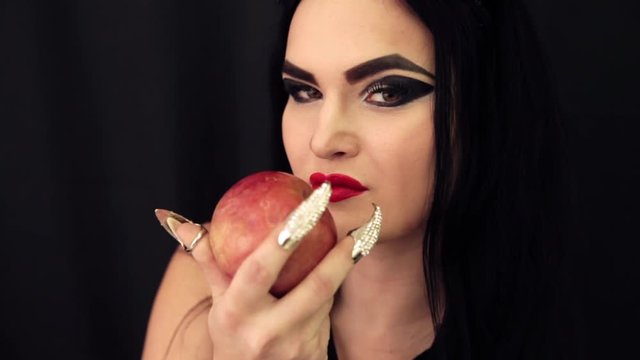 a young witch with an apple in her hands