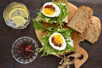 Toast with cream cheese, arugula and boiled egg, healthy breakfast, top view
