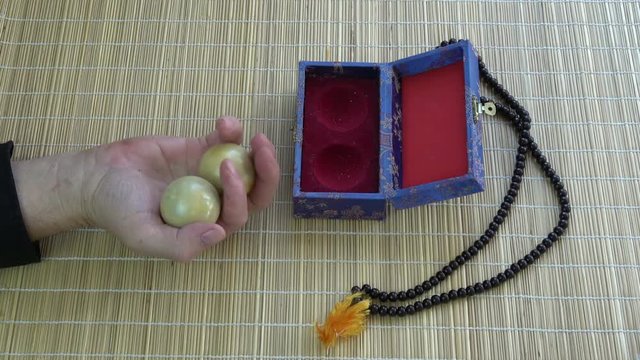 Asian chinese hand massage marble balls in hand  and Buddhist rosary on bamboo mat