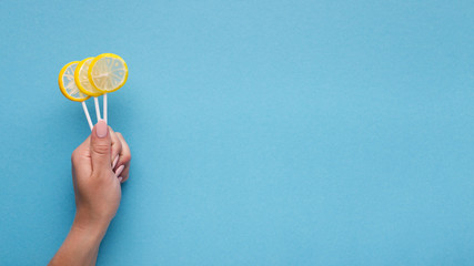 Woman holding candy lollipops on blue backgound
