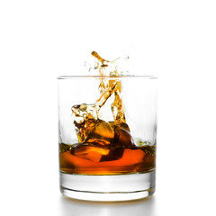 Whisky glass with splashes, isolated on white