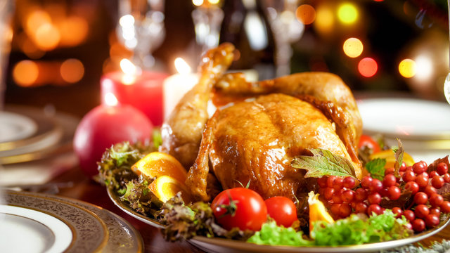 Closeup image of tasty chicken on big dish with vegetables on family festive dinner
