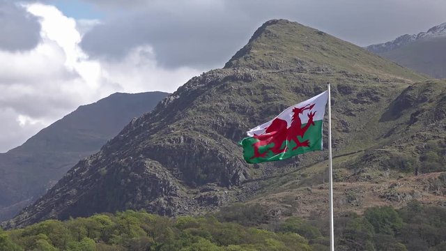 Welsh flag waving in the beautiful landscape of Llanberis, Snowdonia in Wales at the lake padarn