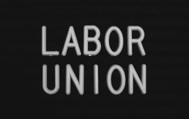 Words labor union written on the letter board. White letters on the black background