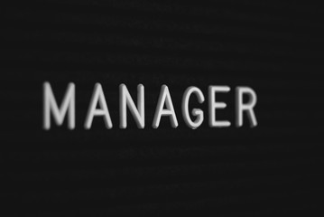 Words manager written on the letter board. White letters on the black background