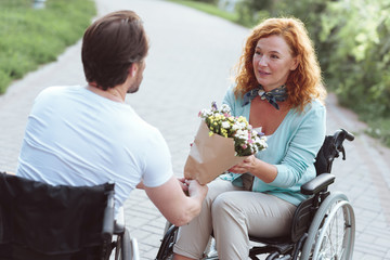 Is this for me. Selective focus on a surprised redhead lady receiving an unexpected bouquet from...