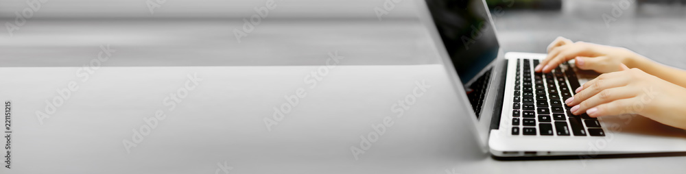 Wall mural banner of laptop and female hands with copyspace in grey color background. concept of blog heading a